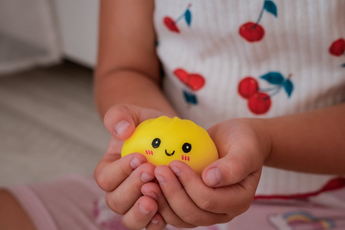 A child holding a dumpling-shaped squishy toy